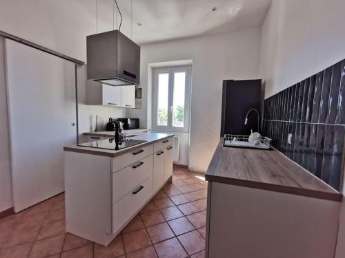 une cuisine avec des armoires blanches et un comptoir dans l'établissement Saint André bel appartement Avignon Intra muros 2 couchages, à Avignon