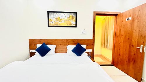 a bedroom with a large bed with blue pillows at Vrindavan Hotel And Restaurant in Sālūmbar