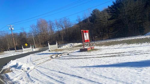 a snow covered road with a sign on the side of it at Pleasant Valley Motel West Stockbridge in West Stockbridge