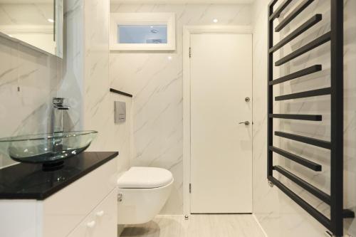 a bathroom with a toilet and a glass sink at The Kingswood Place - Modern 2BDR with Terrace in West Dulwich