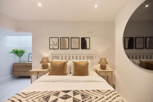 The Kingswood Place - Modern 2BDR with Terrace في West Dulwich: غرفة نوم مع سرير أبيض كبير مع مرآة