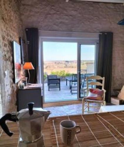 un salon avec vue sur un patio dans l'établissement La Chabourne des remparts, à Saint-Simeux
