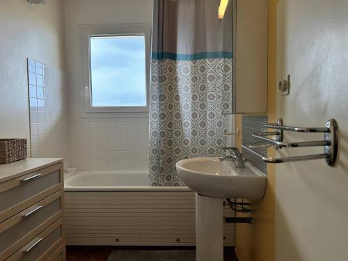 une salle de bain avec un lavabo et une baignoire dans l'établissement 430 - Appartement T2 vue mer, depuis toutes les pièces, à Caroual