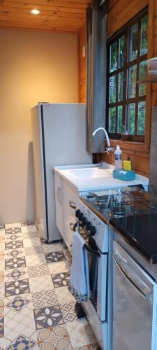 a kitchen with a sink and a stove top oven at Tiny House Novas Palmeiras in Florianópolis