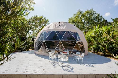 a tent with chairs and a table in it at Bai Tu Long Mountain Resort in Hà Cái