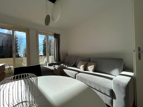 a living room with a couch and a table at Cityscape Prilly près de Lausanne in Prilly