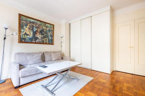 un salon avec un canapé et une table dans l'établissement Studio#Porte Dauphine#Avenue Foch#2pers., à Paris