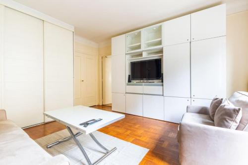 un salon avec un canapé et une table dans l'établissement Studio#Porte Dauphine#Avenue Foch#2pers., à Paris