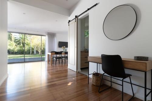 een woonkamer met een tafel en een spiegel aan de muur bij Villa Gwen: Character Home Moments from the City in Invermay