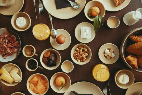 una mesa cubierta con platos y tazones de alimentos para el desayuno en Auberge de Clochemerle - Spa & Restaurant gastronomique étoilé, en Vaux-en-Beaujolais
