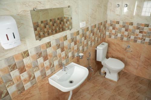 a bathroom with a white toilet and a sink at The Woodlands Residency- Unmarried and stag groups not allowed in Ooty