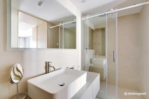 une salle de bain blanche avec un lavabo et une douche dans l'établissement Wonderful apartment 3bedr Saint Honoré, à Paris