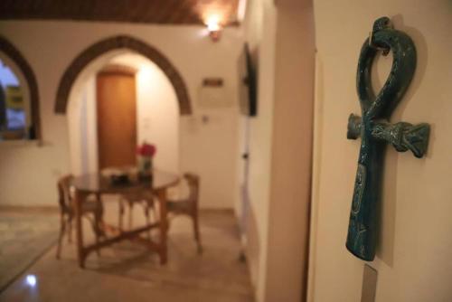 a cross hanging on a wall next to a table at El Hanna Valley View in Luxor