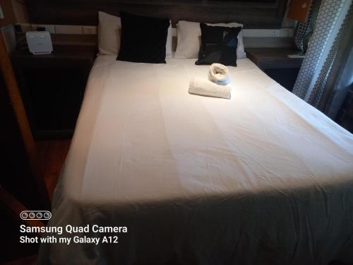 a hotel room with a bed with a towel on it at Secret Guest House in Pietermaritzburg