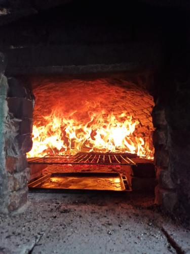 Un horno de ladrillo con fuego. en La casa nella vigna [colline del vino], en Capannori