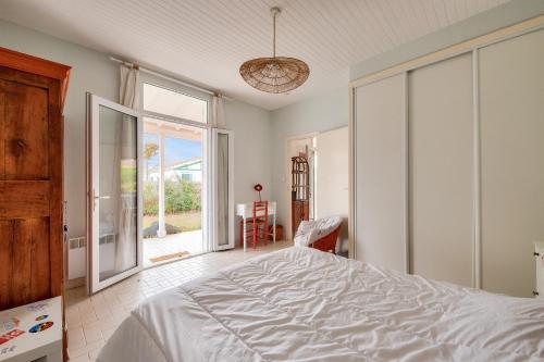 une chambre avec un lit et une grande fenêtre dans l'établissement Séjour apaisant et découverte du Bassin d'Arcachon, à Andernos-les-Bains