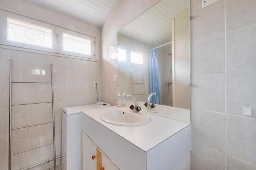 une salle de bain blanche avec deux lavabos et une douche dans l'établissement Séjour apaisant et découverte du Bassin d'Arcachon, à Andernos-les-Bains