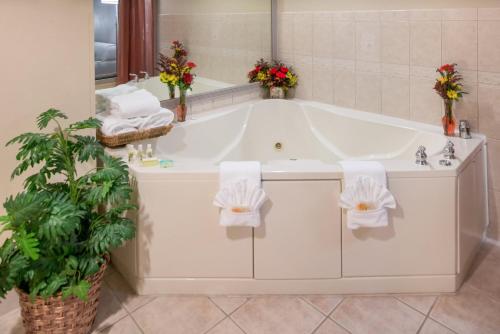 a white bath tub in a bathroom with flowers at Holiday Inn - Belcamp - Aberdeen Area, an IHG Hotel in Belcamp