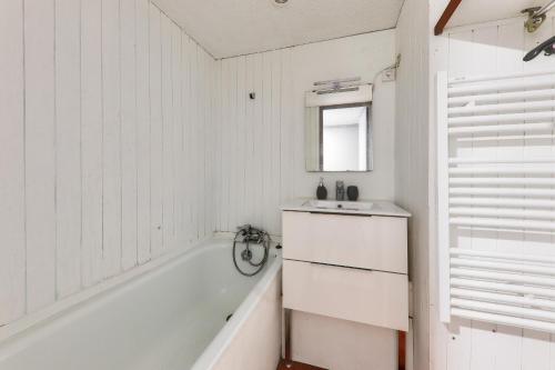 Baño blanco con bañera y lavamanos en Sejour a Arzon a deux pas du Port du Crouesty, en Arzon