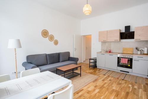 a living room with a blue couch and a kitchen at Vienna City Apartments 1150 Vienna in Vienna