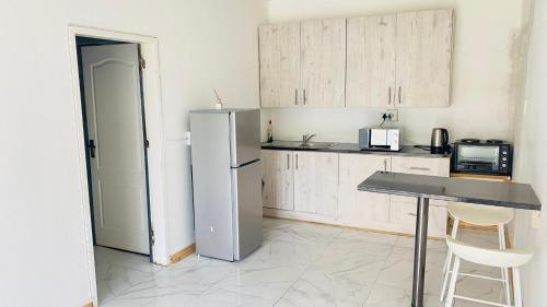 a kitchen with a refrigerator and a table in it at Ubuhle Guest House in Standerton