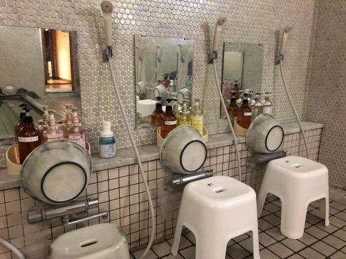 a bathroom with two toilets and two mirrors at Hotel Harumoto in Nikko