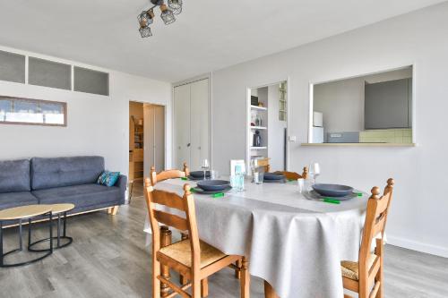 - une salle à manger et un salon avec une table et un canapé dans l'établissement Aux portes de l'océan à Saint-Jean-de-Monts, à Saint-Jean-de-Monts