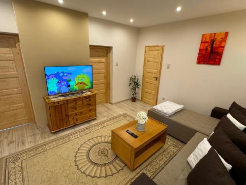 a living room with a couch and a flat screen tv at Patak-parti Vendégház in Bakonynána