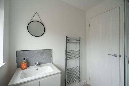 a bathroom with a sink and a mirror on the wall at Woodham House By Horizon Stays in Stockton-on-Tees