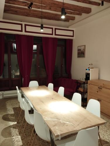 a dining room with a wooden table and white chairs at Ca' Piasentin in Venice