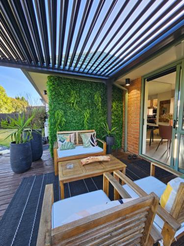 un patio al aire libre con un banco y una mesa en Golden Pearl, en Christchurch