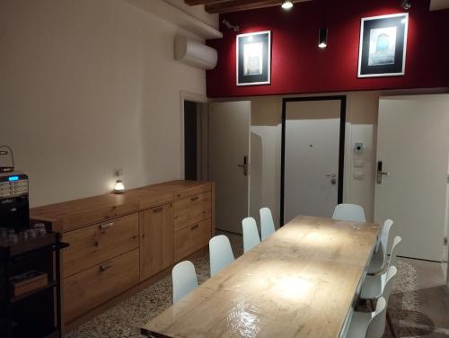 a dining room with a wooden table and white chairs at Ca' Piasentin in Venice