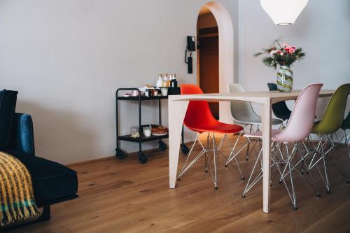 a dining room with a white table and colorful chairs at Appart Hotel Knappaboda in Lech am Arlberg