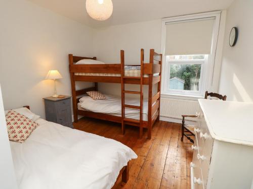 a bedroom with two bunk beds and a window at Fleming House in Cowes