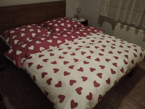 een bed met een rood en wit dekbed met harten bij apartment close to the castle in Bratislava