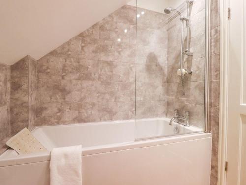a bathroom with a white tub and a shower at The Coach House in Newent