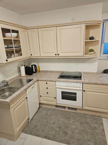 a kitchen with white cabinets and a stove top oven at Schönes Apartment in München in Munich