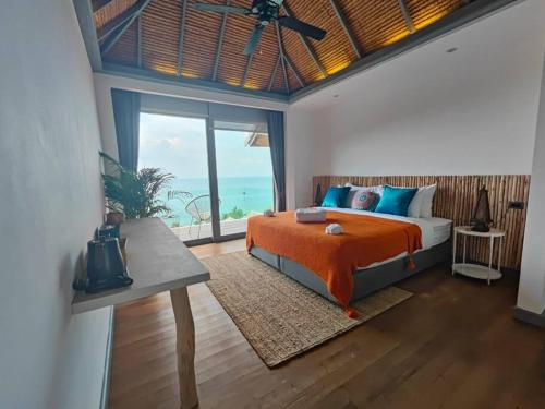 a bedroom with a bed and a view of the ocean at Luxury villa Seaview & Sunset 100m from the beach in Ko Phangan