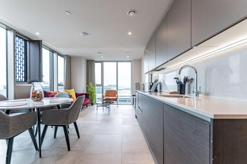a kitchen and living room with a table and chairs at The Lexington - Luxury Serviced Apartments City Centre - City and Waterfront views in Liverpool