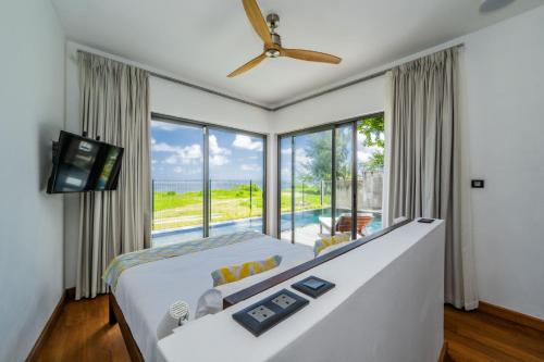 a bedroom with a large bed and a large window at Stunning Beachfront Villa for a Perfect Getaway in Riambel