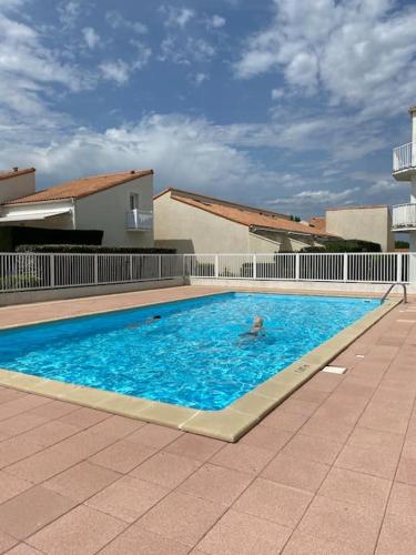 une personne nageant dans une grande piscine dans l'établissement Les Baigneuses Pontaillac T2 jardin piscine, à Vaux-sur-Mer