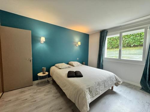 a bedroom with a large bed with a blue wall at Le Primaubois - 2 chambres & parking - Centre La Primaube in Flavin