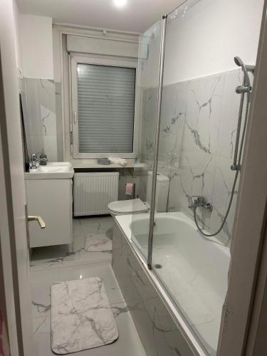 a bathroom with a shower and a tub and a sink at Appartement complet moderne in Saint-Louis