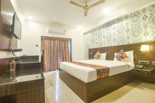 FabHotel Don Hill Beach Resort في Goa: غرفه فندقيه بسرير وحمام