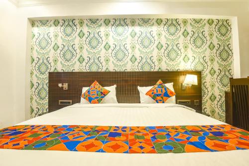 um quarto com uma cama grande e um edredão colorido em FabHotel Don Hill Beach Resort em Goa