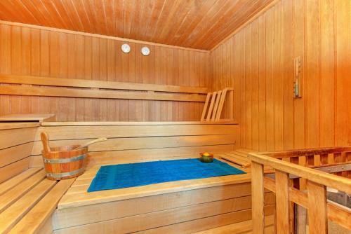 a sauna with a blue tub in a wooden room at Hotel Restaurant Falken in Baiersbronn