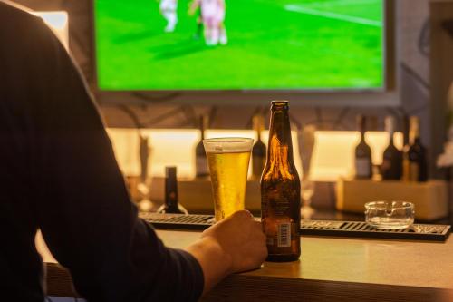 a person holding a glass and a bottle of beer at Ibis Casablanca Sidi Maarouf in Casablanca