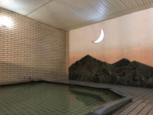 a swimming pool with a crescent moon on the wall at Hotel Harumoto in Nikko