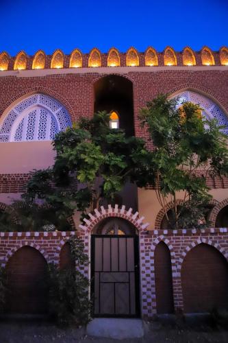 a brick building with a door and a tree at El Hanna Valley View in Luxor
