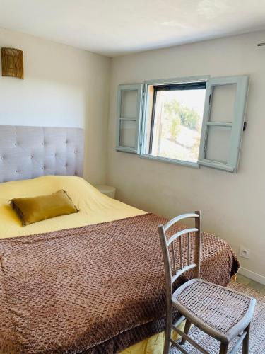 une chambre avec un lit, une chaise et une fenêtre dans l'établissement Maison Murato, à San-Giuliano